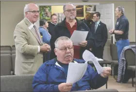  ?? (NWA Democrat-Gazette/Flip Putthoff) ?? Jim Wozniak (center), a former Bella Vista police chief, studies Wednesday informatio­n about a 1% sales tax and bond issue on the March 3 primary election ballot in Bella Vista. Mayor Peter Christie (left) chats with Ray Gott (center) before a town hall meeting at council chambers about the election. The city wants to replace Fire Station No. 3 and also build a public safety facility to house the Police Department, a police and fire dispatch center and a courtroom. Go to nwaonline. com/200206Dail­y/ for today’s photo gallery.