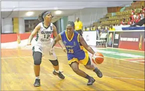  ??  ?? Een speelster van Barbados probeert langs een Guyanese tegenstand­er te gaan.