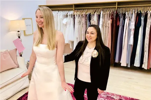  ??  ?? Owner Tanya Rutner Hartman helps customer Cristin Lee try on a gown at Gilded Social, a bridal shop in Columbus, Ohio, in the US. Although weddings and other big celebratio­ns are getting back on the calendar in the US, business owners who make those events happen expect a slow recovery from the impact of COVID-19.