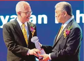  ?? PIC COURTESY OF YAYASAN PAHANG ?? Deputy Prime Minister Datuk Seri Dr Ahmad Zahid Hamidi handing over an award to Yayasan Pahang general manager Datuk Mahmud Mohd Nawawi at the Asia Human Resources Developmen­t Awards 2017 in Putrajaya recently.