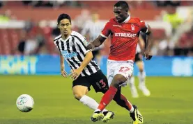  ?? PHOTO: REUTERS ?? Newcastle United’s Yoshinori Muto (left) and Tendayi Darikwa, of Nottingham Forest, vie for the ball during a League Cup game yesterday. Underdog Forest won 31.