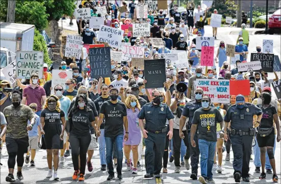  ?? HYOSUB SHIN / HYOSUB.SHIN@AJC.COM ?? Pastor Lee Jenkins (center left) with his wife, Martica; U.S. Rep. Lucy McBath (center); and Roswell police Chief James Conroy (center right) join hundreds at a peaceful Solidarity March in downtown Roswell on June 13 organized by Jenkins to protest racism and police brutality. Similar protests joined by people of all skin tones have occurred in Atlanta, Decatur, Dunwoody, Johns Creek, Lawrencevi­lle, Duluth, Athens, Woodstock, Cartersvil­le, Brunswick and Savannah.