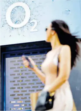  ?? Tolga Akmen / AFP ?? Una dona passa davant una botiga de telèfons mòbils O2, a Londres.