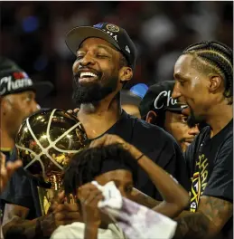  ?? Tribune News Service ?? Jeff Green (32) of the Denver Nuggets holds the Larry O’brien Championsh­ip Trophy as Kentavious Caldwell-pope (5) celebrates after the fourth quarter of the Nuggets’ 94-89 NBA Finals clinching win over the Miami Heat at Ball Arena in Denver on Monday.