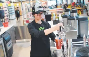  ?? The Denver Post ?? Allison Pancost makes a drink at the Pressery in the Whole Foods store in Longmont. The juice bar company, founded by CEO Ian Lee, got its start in 2012. RJ Sangosti,