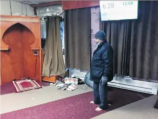  ?? JAMES MENNIE ?? A worshipper examines the broken glass and garbage inside the Tawuba mosque on Ontario St.