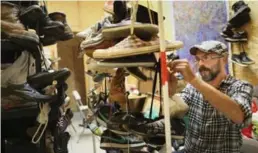  ?? RICHARD LAUTENS/TORONTO STAR ?? Cyril Williams prepares 1,000 pairs of donated shoes for his installati­on.