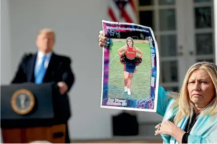  ?? AP ?? US President Donald Trump looks over to Susan Stevens, holding a picture of her daughter Toria, 22, who died of an opioid overdose last year, during an event in the Rose Garden at the White House to declare a national emergency in order to build a wall along the US border with Mexico.