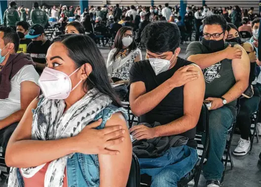  ?? Photos by Jeoffrey Guillemard / Bloomberg ?? People wait in an observatio­n area June 28 after receiving a dose of the Sinovac Biotech vaccine at a site open to those ages 18 to 29 in Mexico City.