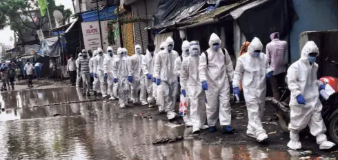  ??  ?? MUNICIPAL HEALTH WORKERS on the way to screen people at the Ambujwadi slum at Malad in Mumbai.