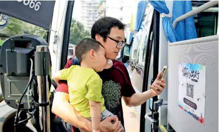  ??  ?? A passenger pays for bus ticket by quick response (QR) code in Beibei District, southwest China’s Chongqing Municipali­ty, on Aug. 3, 2017. Mobile payments started operation in some bus lines in Chongqing since August this year. (Xinhua/Qin Tingfu)