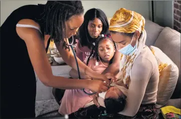  ?? PHOTOS BY SARAH REINGEWIRT­Z — STAFF PHOTOGRAPH­ER ?? Aysha-Samon Stokes and daughter Nyla watch midwife Allegra Hill and student midwife Maryam Karim check the heartbeat of 2-week-old Nikko during a postpartum visit to the South L.A. birthing center where he was born on Mother’s Day.