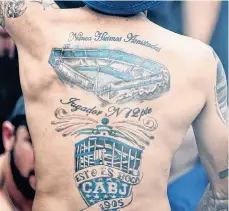  ?? /GETTY IMAGES ?? Este aficionado presume su amor por Boca Juniors con su espalda tatuada con imágenes del equipo.