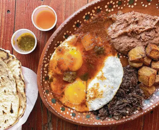  ?? Photos by Mike Sutter / Staff ?? A huevos rancheros plate comes with machacado and handmade flour tortillas at Birotes Restaurant & Bakery in Universal City.