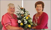  ??  ?? Joan Collins (Clinical Nurse Manager 2) makes a floral presentati­on to Brosna native Peg Fitzgerald on her final day as Matron at Kanturk Community Hospital.