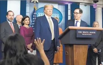  ?? Evan Vucci Associated Press ?? PRESIDENT TRUMP, with Treasury Secretary Steven T. Mnuchin and coronaviru­s task force members at a White House news briefing on Tuesday, said, “Everything else will come back. Lives won’t come back.”