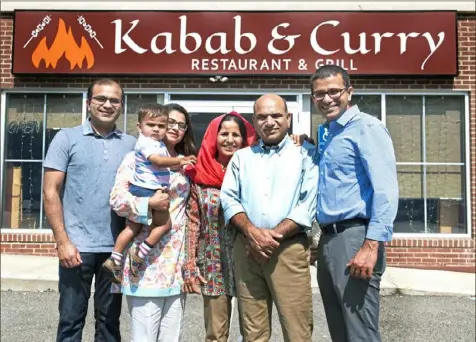  ?? Pittsburgh Post-Gazette ?? Muhammad Chatha, left, with son, Yusuf, his wife, Bushra, his parents, Iqbal and Pervez Chatha, and brother, Bilal Chatha, in front of the family's Kabab & Curry Restaurant and Grill in Banksville.