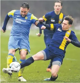  ??  ?? Kings Hill (dark blue) put Hawkinge under pressure during their 2-1 defeat by the Kent County League, Division 1 leaders on Saturday. A groundsman clears the lines