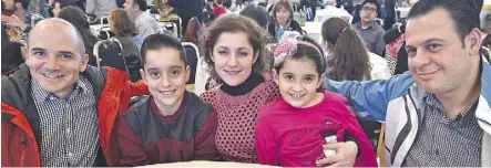  ??  ?? The Salamah family, including, from right, dad Misheel, daughter Anjelina, 7, wife Jalila and son Youseff, 13, with their sponsor Rob Stobbe, left, at a Friday multicultu­ral welcome dinner for incoming Syrian refugees, which was organized by the Mennonite Centre for Newcomers at the Portuguese Canadian Hall in Edmonton.