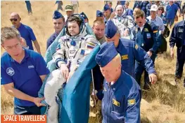  ?? — AP ?? Support and medical personnel carry Expedition 31 Commander Oleg Kononenko of Russia, foreground, and Flight Engineers Andre Kuipers of the European Space Agency, centre, and Don Pettit of Nasa, background, to the medical tent shortly after they landed...