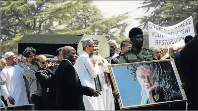  ?? Picture: REUTERS ?? LAST JOURNEY: Friends and family carry the body of Ahmed Kathrada to his burial at the Westpark Cemetery in Johannesbu­rg, as a veteran holds a framed picture of the struggle veteran