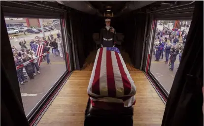  ?? AP photo ?? The flagdraped casket of former President George H.W. Bush passes through Magnolia, Texas, on Thursday, along the train route from Spring to College Station, Texas.