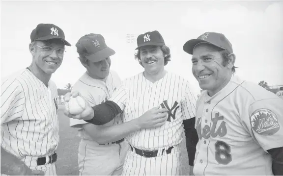  ?? BILL HUDSON/AP FILES ?? New York Yankees pitcher Catfish Hunter, second from right. batted .350 in 1971, two years before the American League adopted the designated hitter rule.