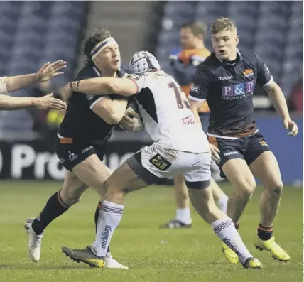  ??  ?? Edinburgh’s Hamish Watson is stopped in his tracks by Ulster’s Luke Marshall at BT Murrayfiel­d on a night when the hosts’ hopes of reaching next season’s Champions Cup also took a hit.