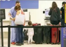  ?? GABE HERNANDEZ/CORPUS CHRISTI CALLER-TIMES VIA AP ?? Michael Reyes, left, who is a general surgeon, hugs his wife Sara Reyes as she prepares to fly out of Corpus Christi with her daughter Eva Reyes and he prepares to stay as Hurricane Harvey approaches the Gulf Coast area on Friday, at the Corpus Christi...