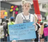  ?? PAT NABONG/SUN-TIMES ?? Lucy Christians­on, 26, a teacher, holds a sign that reads “My students shouldn’t have to be afraid they won’t make it to 14” during a protest for stricter gun laws at Federal Plaza in the Loop.