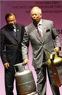  ??  ?? There’s a difference: Najib exhibiting the weight of the old and the new gas cylinders in Putrajaya yesterday as Domestic Trade, Cooperativ­e and Consumeris­m Minister Datuk Seri Ismail Sabri Yaakob looks on.