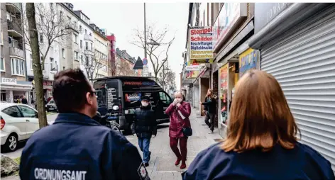  ?? RP-FOTO: HANS-JÜRGEN BAUER ?? Die OSD-Kräfte Simone Schütten und Bastian Ufer am Freitag auf der Kölner Straßen: Viele Geschäfte sind ordnungsge­mäß geschlosse­n.