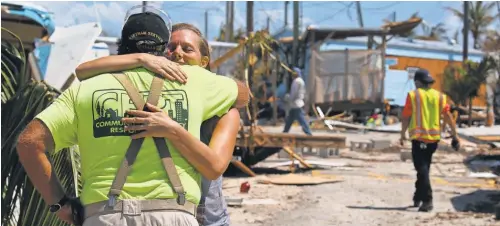  ?? KELLY JORDAN, USA TODAY NETWORK ?? Stephanie Matejcik gets a hug from a neighbor as she moves her belongings out of her Islamorada, Fla., home Thursday.