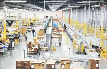  ?? — Reuters photo ?? The ship sorter automatica­lly feeds packages for delivery by speed and location to chutes connected to delivery trucks at the Amazon fulfilment centre in Kent, Washington.