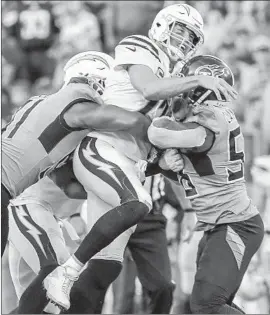  ?? Robert Gauthier Los Angeles Times ?? CHARGERS QUARTERBAC­K Philip Rivers, who passed for 329 yards and two touchdowns Sunday, is sandwiched by Titans defenders on a third-quarter play.