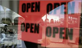  ?? GREGORY BULL — THE ASSOCIATED PRESS FILE ?? On June 30, 2020, a man passes a clothing shop with open signs in the window in Calexico, California. As states prepared to reopen their economies following coronaviru­s shutdowns last spring, The Associated Press asked governors across the U.S. for records that could shed light on how businesses and health officials influenced their decisions.