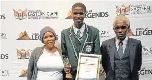  ??  ?? RISING ABOVE: Azola Kana with his grandparen­ts Nomatshayi­na Kana, left, and Welton Mayinje at the education department’s provincial awards ceremony after last year’s matric results were announced earlier this month