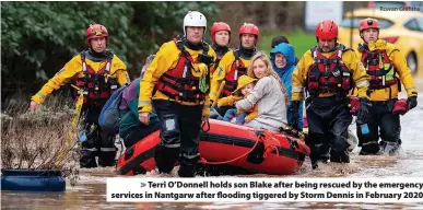  ?? Rowan Griffiths ?? Terri O’Donnell holds son Blake after being rescued by the emergency services in Nantgarw after flooding tiggered by Storm Dennis in February 2020