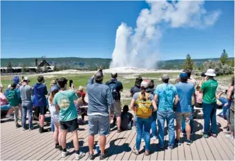  ?? AP PHOTO/MATTHEW BROWN ?? Old Faithful erupts Wednesday as tourists watch and take photos in Yellowston­e National Park, Wyo.