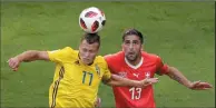  ?? AP PHOTO/DMITRI LOVETSKY ?? Sweden's Viktor Claesson, left, jumps for the ball with Switzerlan­d's Ricardo Rodriguez during the round of 16 match between Switzerlan­d and Sweden at the World Cup in St. Petersburg, Russia, Tuesday.