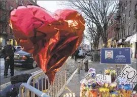  ?? Yuki Iwamura Associated Press ?? A MEMORIAL honors one of the two slain New York officers outside the Police Department’s 32nd Precinct. A third officer shot the gunman, who also died.