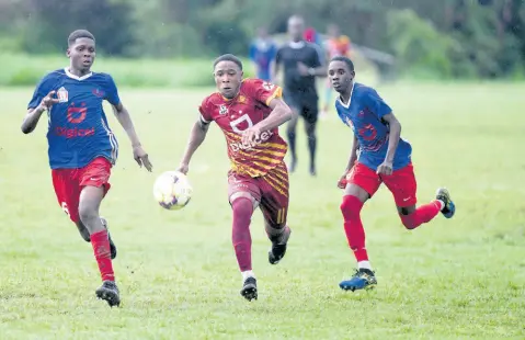  ?? RICARDO MAKYN/CHIEF PHOTO EDITOR ?? Dante Dacres (centre) of Wolmer’s Boys getting away from Camperdown High’s Nashaun Miller (left) and Ramone Francis during last Friday’s Issa/digicel Manning Cup encounter at Alpha Institute. Camperdown won 1-0.