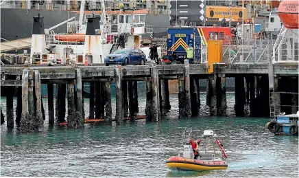  ?? PHOTO MARION VAN DIJK/FAIRFAX NZ ?? Police investigat­e the scene where a car has been found in the harbour beside a wharf at Port Nelson.