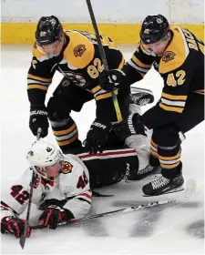  ?? MATT STONE / BOSTON HERALD ?? TEAMWORK: Trent Frederic (left) and David Backes knocks the Blackhawks’ Gustav Forsling to the ice during the Bruins’ victory Tuesday at the Garden.