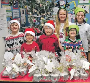  ??  ?? The school’s six pupils with their individual­ly packaged Christmas cakes.