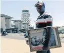  ?? Picture: AFP/ JEKESAI NJIKIZANA ?? MEMORIES: A man carries a portrait of late former Zimbabwe president Robert Mugabe. Mugabe died in Singapore last week.