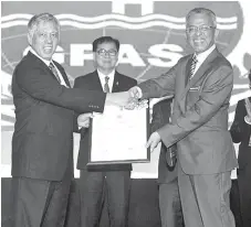  ??  ?? Tan Sri Ibrahim Menudin (left) receiving the award from Dato’ Kamarudin Jaafar in the presence of Datuk Frankie Poon (Sabah Health and People’s Wellbeing Minister) representi­ng the Chief Minister of Sabah, Ng Kiat Min (Group Managing Director, Suria Capital Holdings Berhad) and Siti Noraishah Azizan (General Manager, Sabah Ports Sdn Bhd).