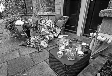  ??  ?? Voor de woning in de Eerste Atjehstraa­t zijn bloemen en kaarsen neergezet. (Foto: De Telegraaf)