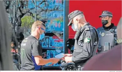  ?? MANUEL ARANDA ?? Un motorista muestra su documentac­ión a un agente de la Policía Local en uno de los controles del fin de semana.