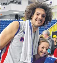  ?? DAVID JALA/CAPE BRETON POST ?? Aly Ahmed of the Cape Breton Highlander­s poses with a fan following a National Basketball League of Canada game at Centre 200. The 25-year-old centre from Alexandria, Egypt, is in his first season of profession­al basketball.